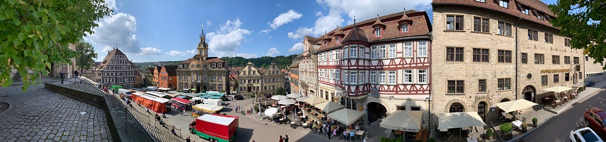 Schwäbisch Hall, Germany - September, 11 - 2019: View of the town square with medieval buildings, market stands, restaurants, shops and tourists.