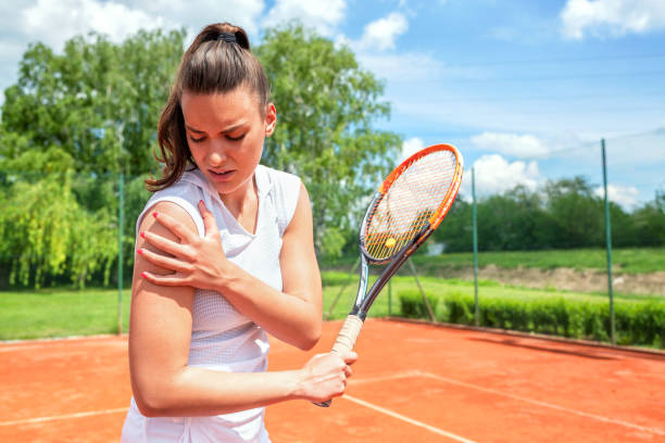 bella ragazza ferita durante l'allenamento di tennis - shoulder pain physical injury human arm foto e immagini stock