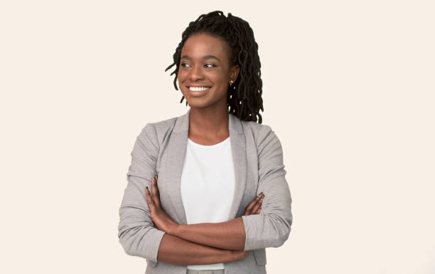 черная бизнес-леди улыбаясь глядя в сторону стоя на белом фоне - aside стоковые фото и изображения