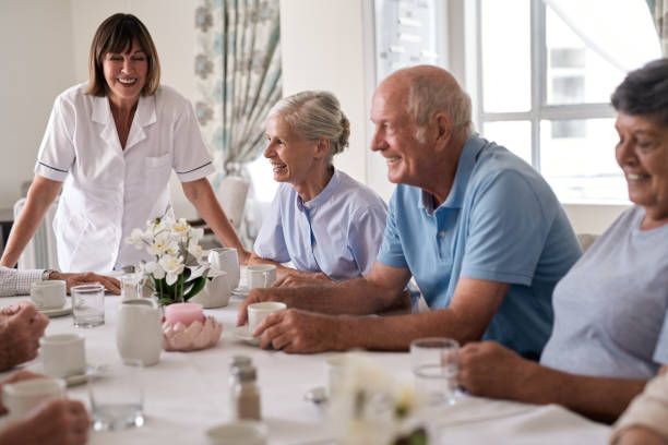 istock Laughing seniors talking to a nurse during afternoon tea 1182630117