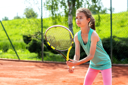 Dulce niña sosteniendo una raqueta de tenis photo