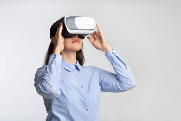 istock Young Woman In Virtual Reality Headset Standing Over Gray Background 1182630468
