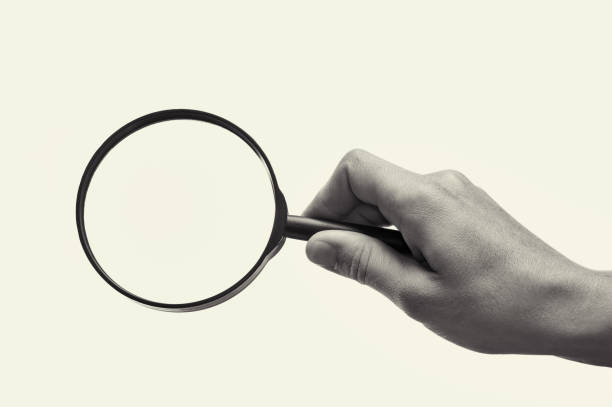 istock Magnifying glass in woman hand. Black and white. 1182631603