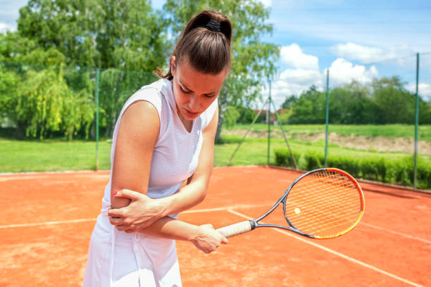 armverletzung beim tennistraining - tennis women action lifestyles stock-fotos und bilder