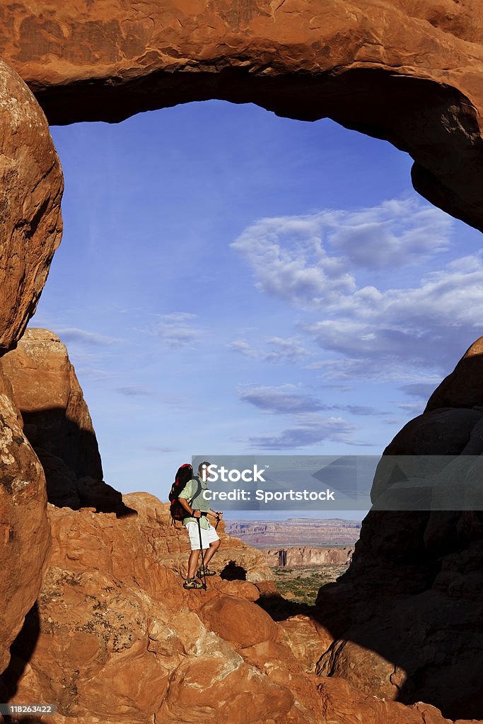 Homem de pé sobre sapatos de Rocky parapeito com enorme Arco - Royalty-free Admirar a Vista Foto de stock