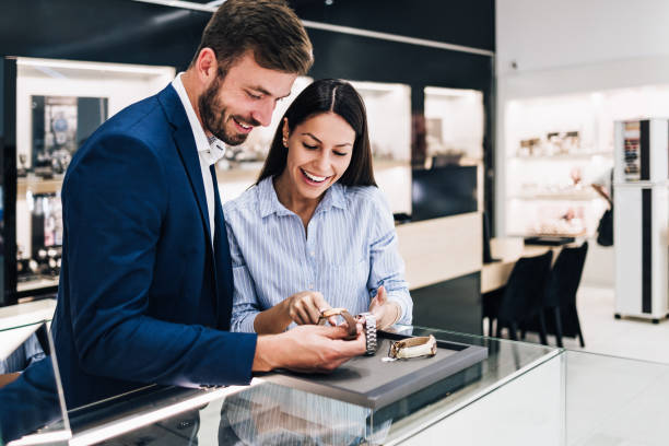 Middle age couple in jewelry store Beautiful couple enjoying in shopping at modern jewelry store while trying out and buying watches. jewelry store stock pictures, royalty-free photos & images