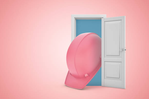 istock 3d rendering of huge pink hard hat emerging from white door on pink gradient copy space background. 1182640367