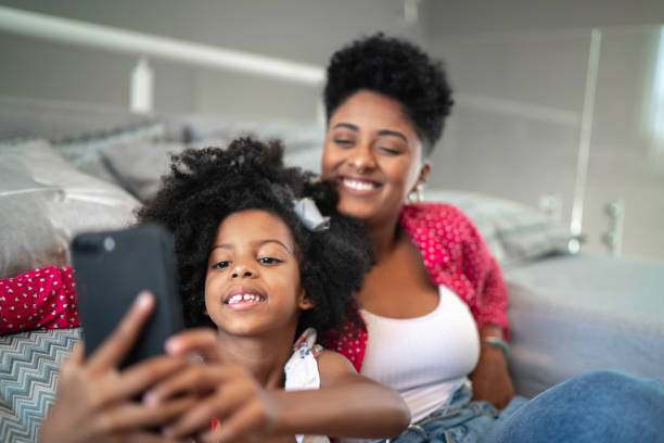 istock Sisters taking a selfie sitting in the couch 1182641870