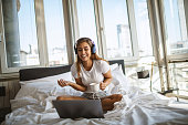 Beautiful smiling woman with headphones in bed