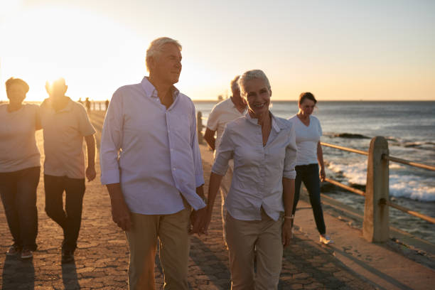 istock Senior couple and friends walking on a seaside boardwalk 1182642012