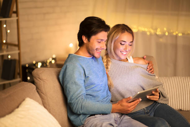 istock Loving millennial couple browsing social media on tablet 1182642199