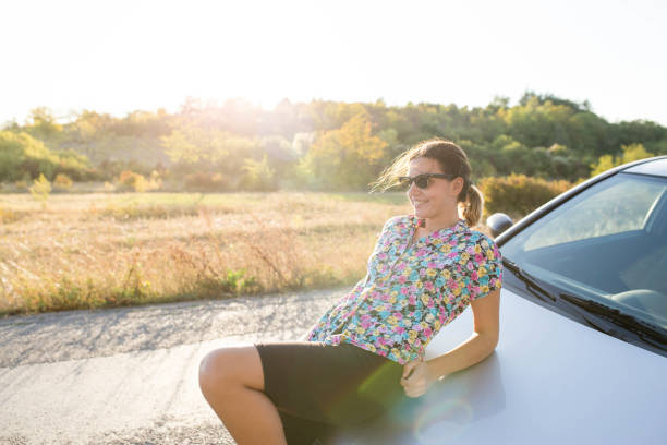 istock Girl leaning on car enjoying outside 1182642376