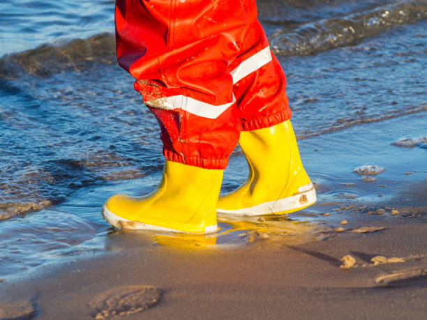 istock Child with rubber boots on the sea 1182643078