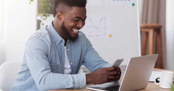 istock Happy black manager looking at smartphone screen reading pleasant message 1182643168