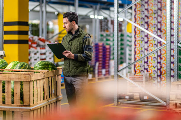 istock Male worker checking watermelon shipment in warehouse 1182645046