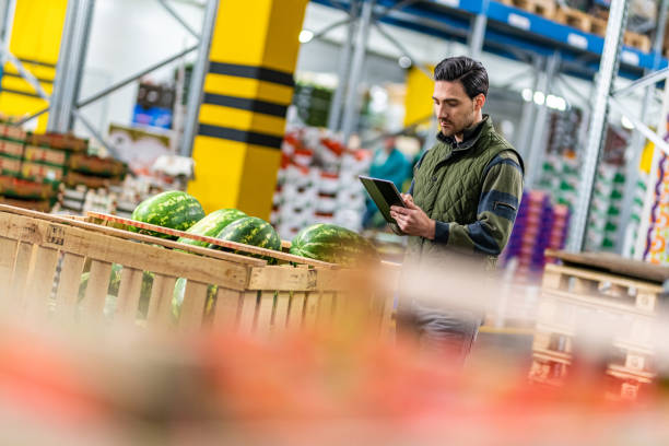 Male worker checking watermelon shipment in warehouse