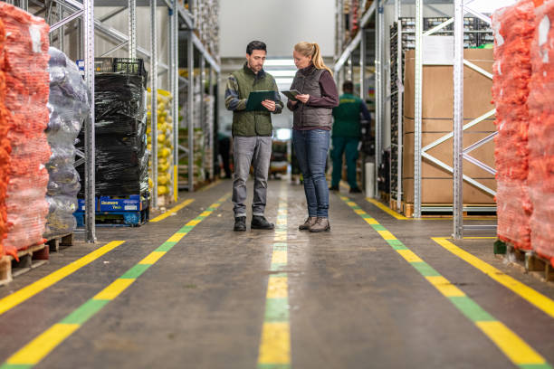 istock Workers with clipboard and digital tablet in warehouse 1182645077