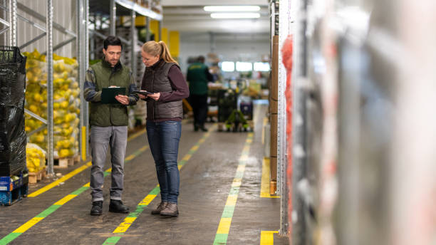 istock Workers with clipboard and digital tablet in warehouse 1182645095