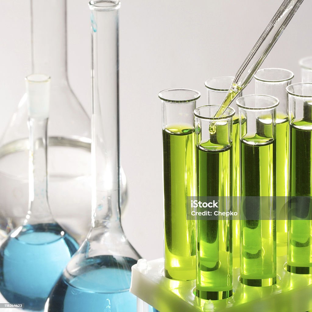 Clear test tubes with blue and green liquids inside test tubes and dropper Biochemistry Stock Photo