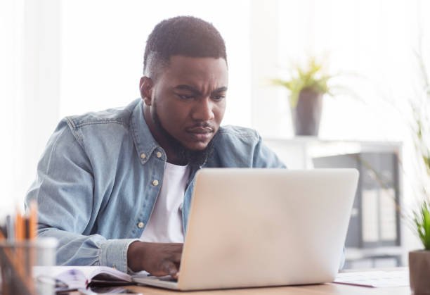 istock Focused african american employee working on laptop in office 1182647525