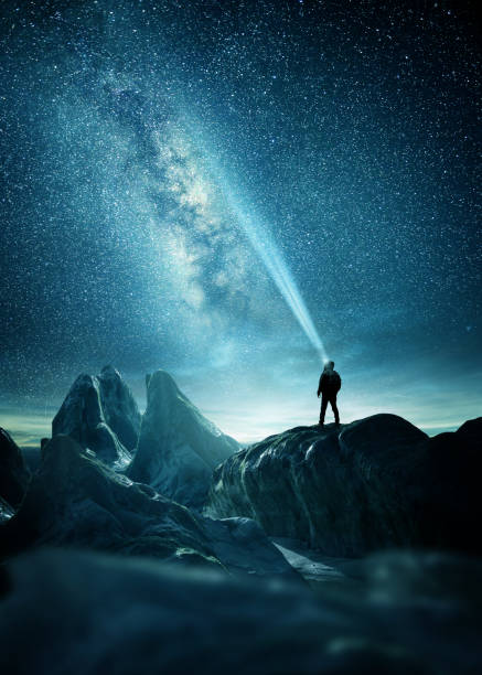 A Man Shining A Light Into The Night Sky