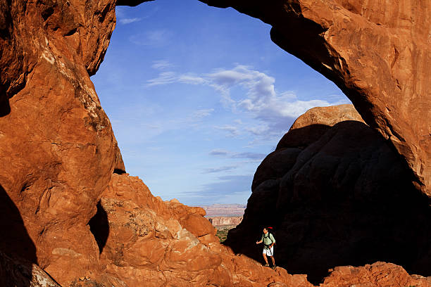 istock Backpacker Climbing Massive Rock Under Arch In Moab, Utah 118264837