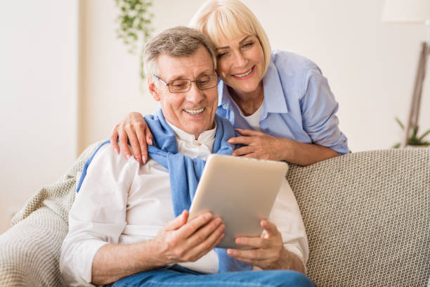 istock Smiling mature couple talking by video-call on tablet 1182648962