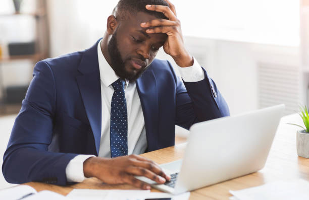 istock Depressed guy sitting in front of laptop at workplace 1182648968