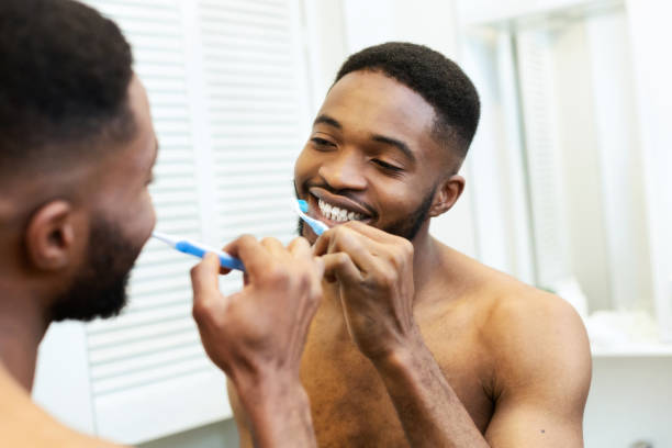 istock Millennial black guy brushing his teeth in bathroom 1182649016