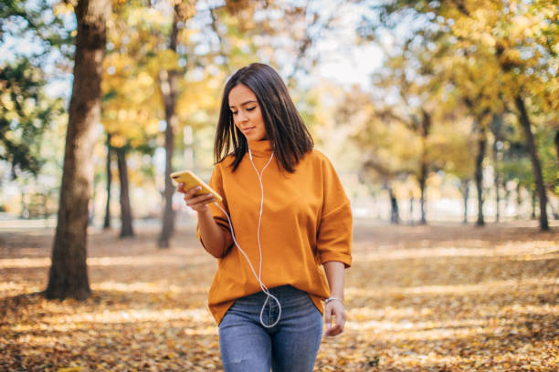 istock Beautiful woman using phone in park 1182649164
