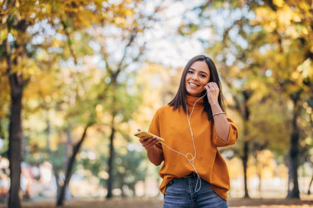istock Beautiful lady using phone in park 1182649182