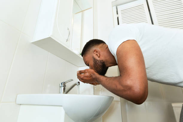 istock African man washing his face in bathroom 1182649331