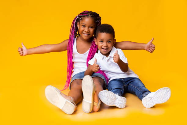 entzückende kleine schwarze schwester und bruder zeigt daumen nach oben - african ethnicity brother ethnic little boys stock-fotos und bilder