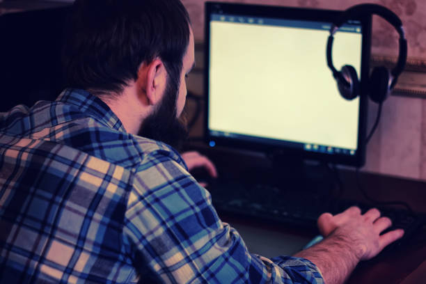 istock male behind computer with headphones 1182650530