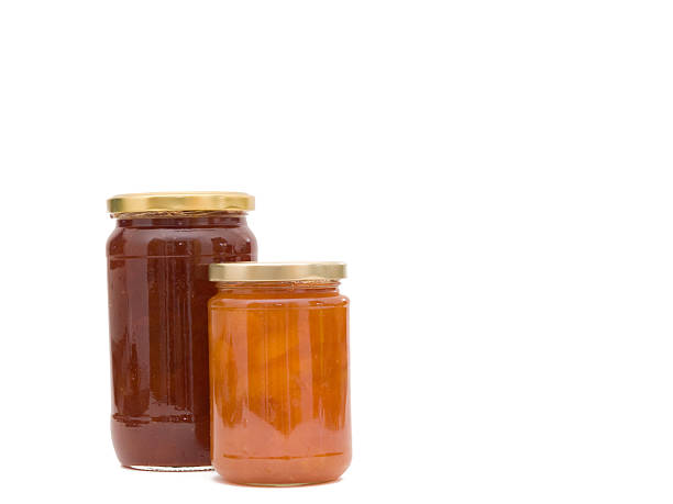 Jars of homemade apricot jam isolated on white
