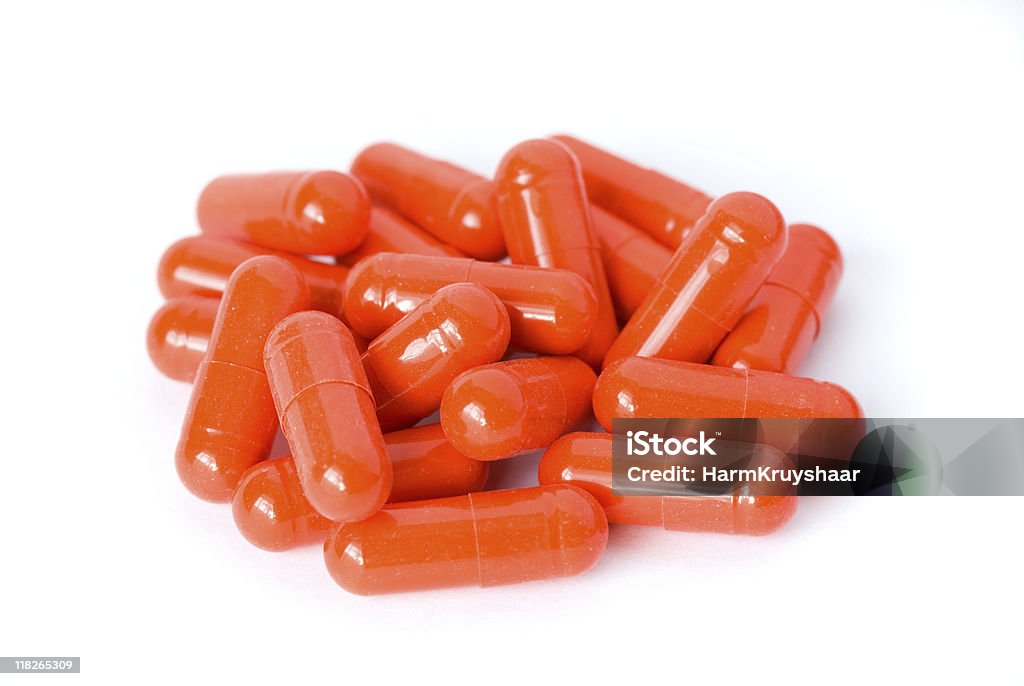 Stos czerwone kapsułki i tabletki na białym tle - Zbiór zdjęć royalty-free (Antybiotyk)