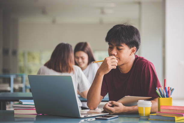 istock Education concept - Students using laptop and learning online at university. Teens and modern technology 1182654241