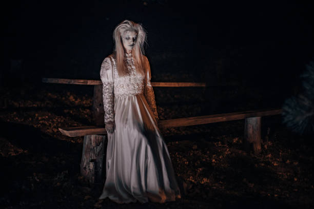 istock Witch sitting on bench in the dark 1182655680