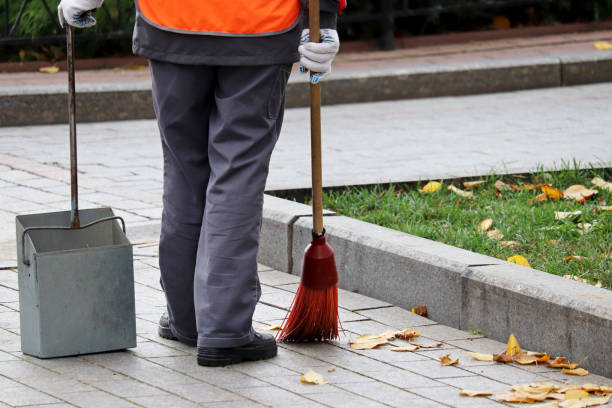 istock Janitor sweeping the fallen leaves on a autumn street 1182655810