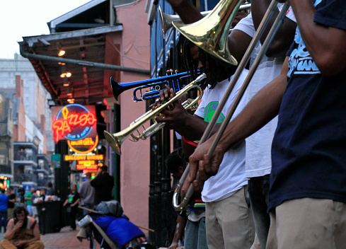 12 April 2018 - New Orleans, Louisiana / United States: Jazz musicians performing in the French Quarter of New Orleans, Louisiana, with crowds and neon lights in the background.