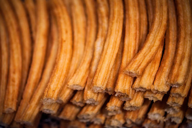 Pile of hot Madrid Churros stacked on a tray, arranged in row stock photo