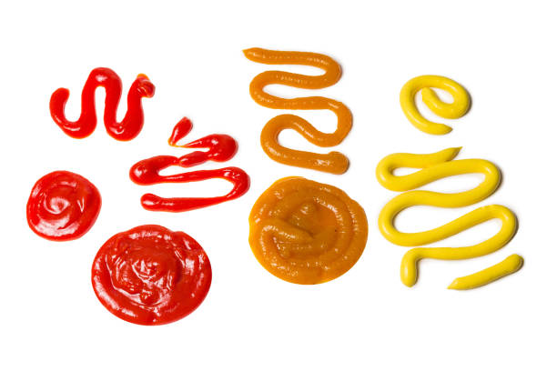 istock Ketchup and yellow sauce splashes isolated on white background. 1182659412