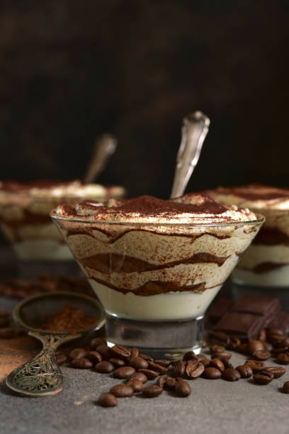 Tiramisu - traditional italian dessert from mascarpone cheese and biscuit Tiramisu - traditional italian dessert from mascarpone cheese and biscuit in a glasses on a dark slate, stone or concrete background. No baked chessecake. parfait photos stock pictures, royalty-free photos & images