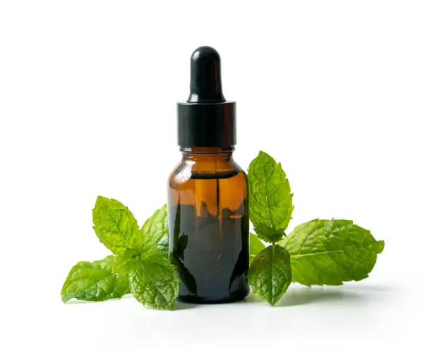 Photo of bottle with mint essential oil and green leaf isolated on white background
