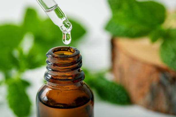 istock mint essential oil drop falling from dropper into the bottle 1182662321