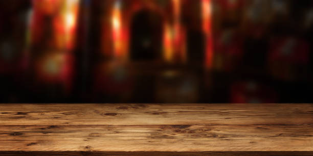 istock Wood table surface in front of red gloomy vault 1182664094