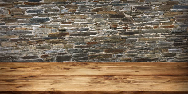 istock Wood surface in front of old stone wall 1182664095