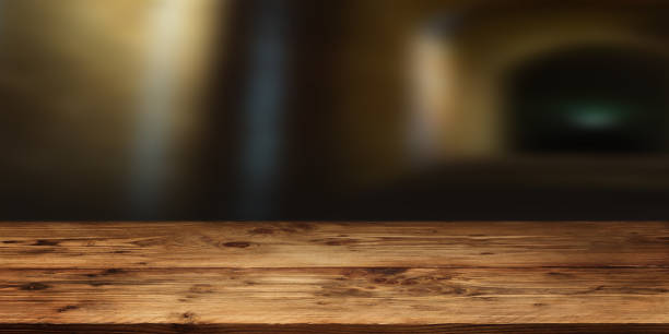 istock Wood table surface in front of gloomy vault 1182664105