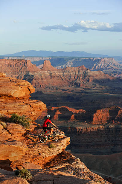 istock Mountainbiker Parked On Edge Of Massive Rocks Looking At View 118266450
