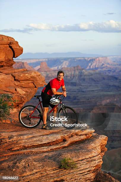 Photo libre de droit de Jeune Homme Assis Sur Mountainbike Du Parc National De Canyonlands banque d'images et plus d'images libres de droit de Activité de loisirs